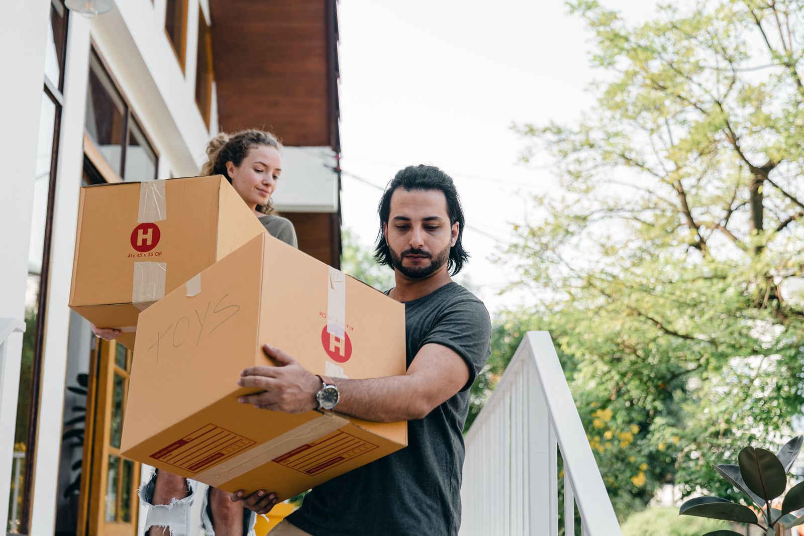 Movers carrying boxes down exterior steps
